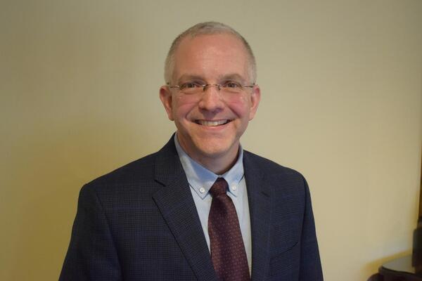 Chris Hakala, a light-skinned man with short gray hair, wearing a business suit, tie and glasses.