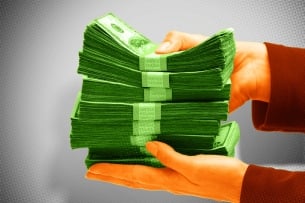 A photo illustration of hands holding a stack of money.