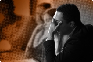 A photo illustration showing a Black man, surrounded by white colleagues, putting his face in his hand. 