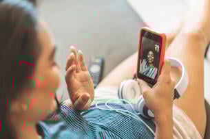 A young woman takes a video call on her phone