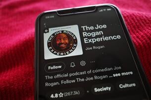 A photo of a smartphone displaying the Spotify landing page for "The Joe Rogan Experience."
