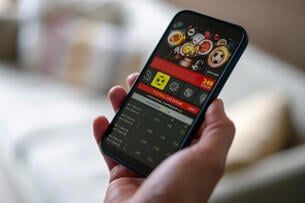 Close-up on a man gambling on a football game on a mobile application - sports betting concepts.