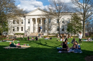 Students lie on blankets on the lawn in front of a building on American University’s campus in Washington, D.C.