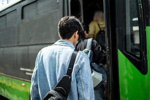 Young man getting on the bus