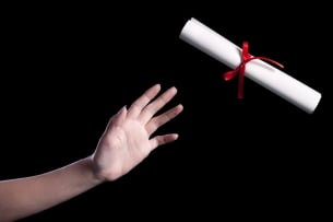 A hand reaching for a diploma