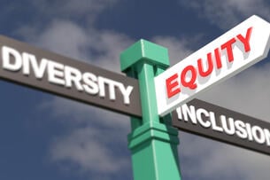 Three directional road signs on a single pole point in different directions -- one says Diversity, one Inclusion, and one Equity.