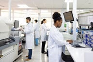 A group of four scientists of different races and genders work in a research laboratory.