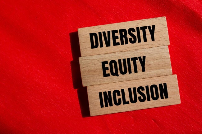 Three wooden blocks with the words "Diversity," "Equity" and "Inclusion" against a red background.