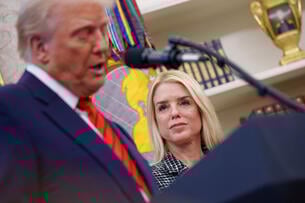 President Trump speaks at a podium while Attorney General Pam Bondi looks on, smiling, in a photo taken in February in the Oval Office.