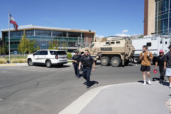 Armed police officers walk in a parking lot at Utah Valley University