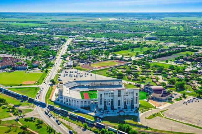 Aerial shot of San Marcos with residential homes, storefronts and the Texas State University campus.