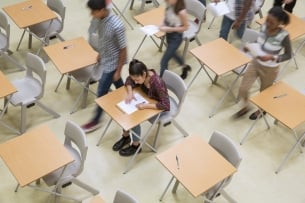 Elevated view of students writing their exam in classroom