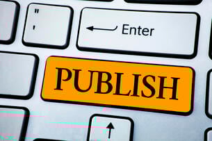 A computer keyboard with a big orange key that says "PUBLISH," directly beneath the enter key.