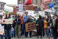 Protesters carry signs during a "Hands Off" protest rally in Detroit, Michigan.
