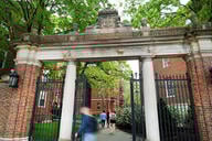 People enter Harvard Yard through a gate.
