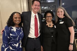 Four people in a photo, three women and one man