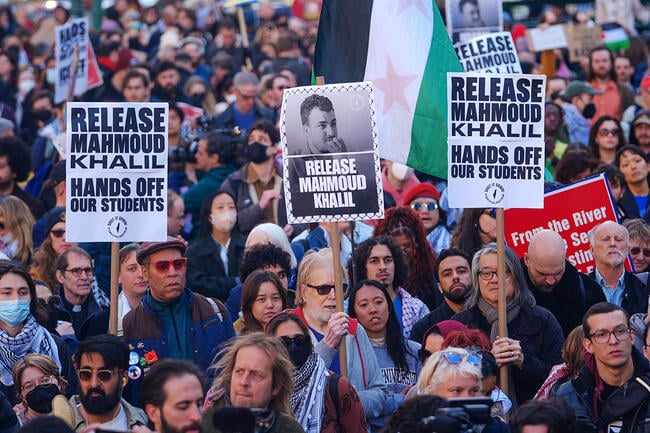 Protesters hold signs with Mahmoud Khalil's face on them to protest his arrest