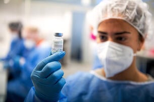 A staff member from the vaccination center at Brill holds a bottle of Moderna's Spikevax vaccine.