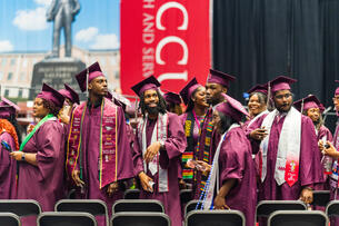 Students in maroon caps and gowns celebrate graduation at NCCU