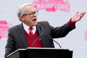 Ohio governor Mike DeWine gestures at a podium. 