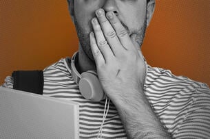 A student with their hand placed over their mouth. 