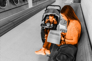 A photo illustration of a student parent studying while doing laundry.