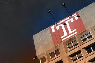 A projection of the Temple T logo on the side of a building.