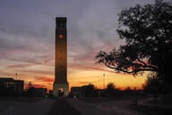 The sun setting behind Texas A&M University’s clock tower.