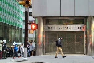 A photo of a person walking outside the King's College.