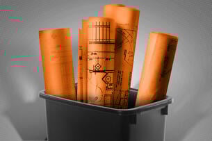 Blueprints sticking out of a trash can.