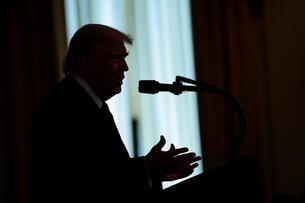 A silhouette of U.S. President Donald Trump taking questions.